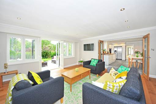A living room with a grey couch and a yellow throw pillow.