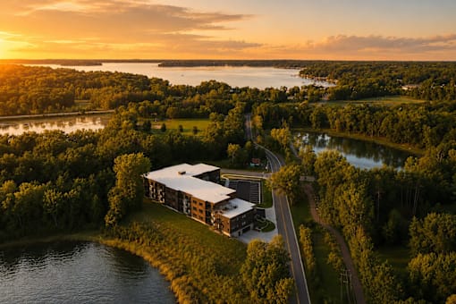 A building is surrounded by trees and water.