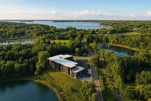A building is surrounded by trees and water.
