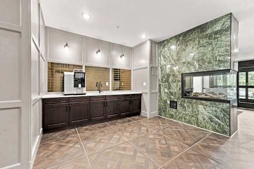A kitchen with a marble backsplash and dark wood cabinets.