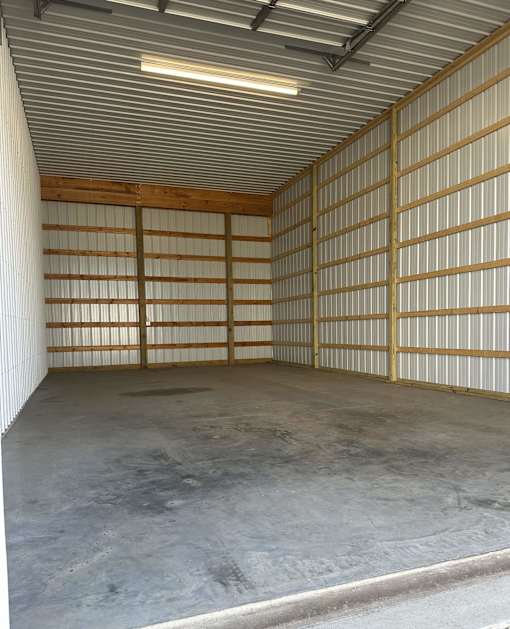 A large, empty garage with a concrete floor and a metal wall.