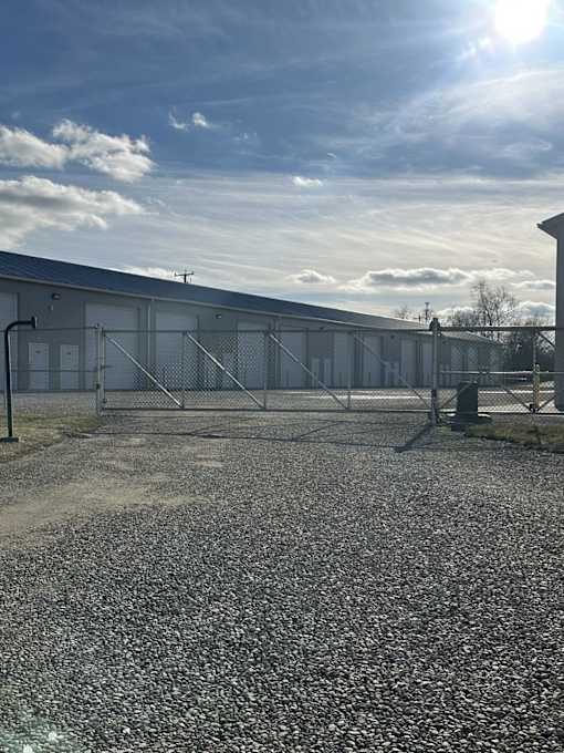 A gravel area in front of a fenced building.