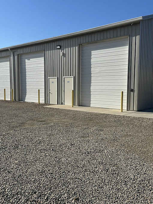 A building with grey walls and white roller doors.