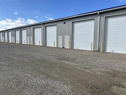 A long row of storage units with closed grey doors.