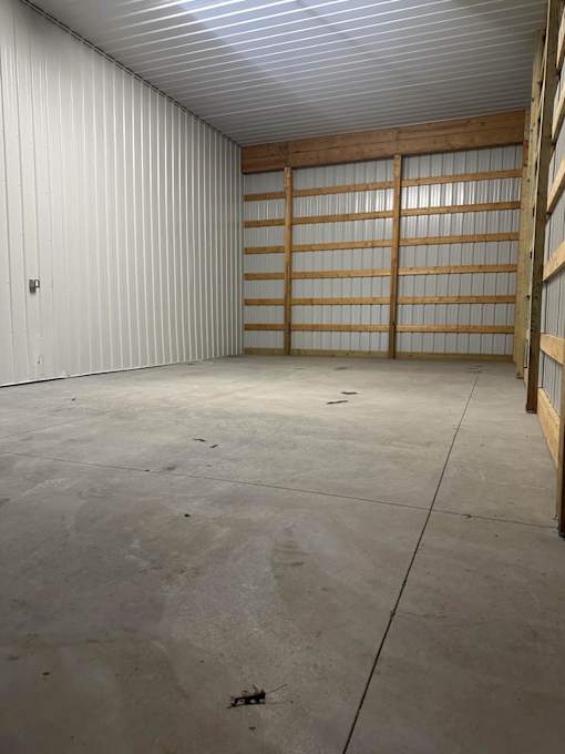 A large, empty garage with a white interior and a concrete floor.