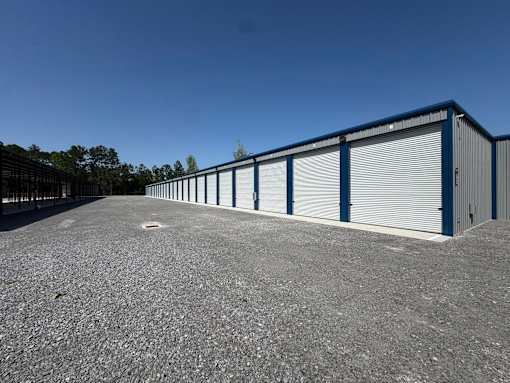 A parking lot with a long row of storage units.