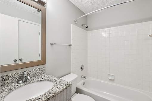 A white bathroom with a sink, toilet, and bathtub at Grand Valley Apartments, OH, 46150