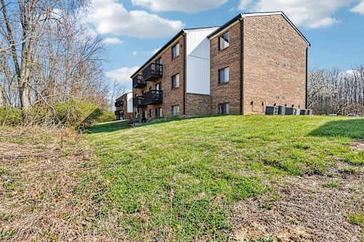 A large brick building with a balcony on the second floor at Grand  Valley Apartments, Milford, OH, 46150