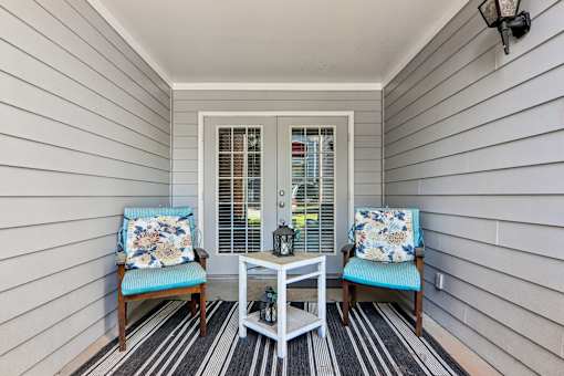 A small porch with a table and two chairs.