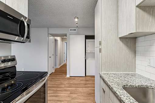 A kitchen with a stove top oven and a sink at Grand  Valley Apartments, Milford, Ohio, 46150