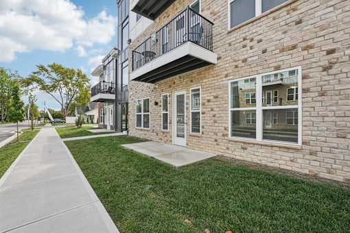 A brick building with a balcony and a walkway in front.