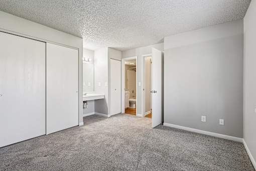 A sparsely furnished room with a white wardrobe and a desk at Grand  Valley Apartments, Milford, Ohio, 46150