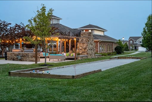 A house with a stone chimney and a gazebo with lights.