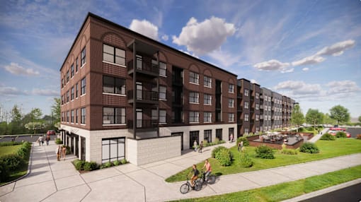 A modern apartment complex with a courtyard and people walking around.