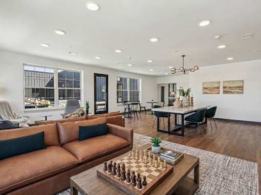 A living room with a chess board on the coffee table.