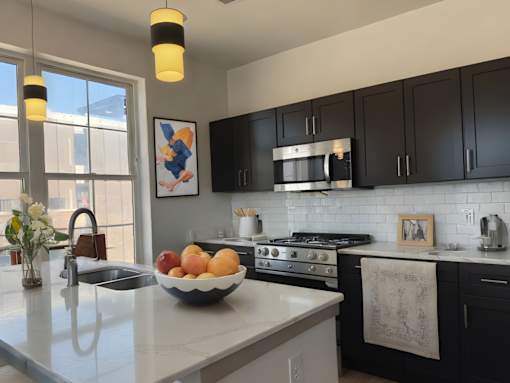 A modern kitchen with black cabinets and a white countertop.
