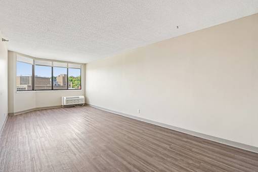 Bright Irvine Park Towers apartment living room with large windows and wood-look flooring