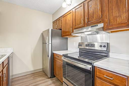 Irvine Park Towers apartment kitchen with wood cabinetry and breakfast bar opening to the living area