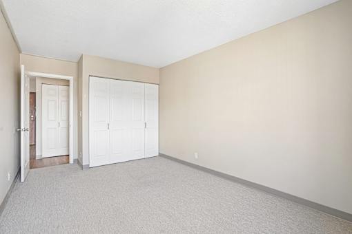 Irvine Park Towers apartment bedroom with carpet, double closet doors and neutral walls
