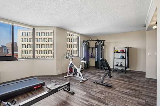 Irvine Park Towers fitness center with strength equipment, stationary bike and city views