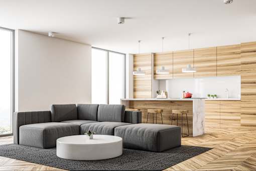 A grey sofa set in a modern living room with a round coffee table in the middle.