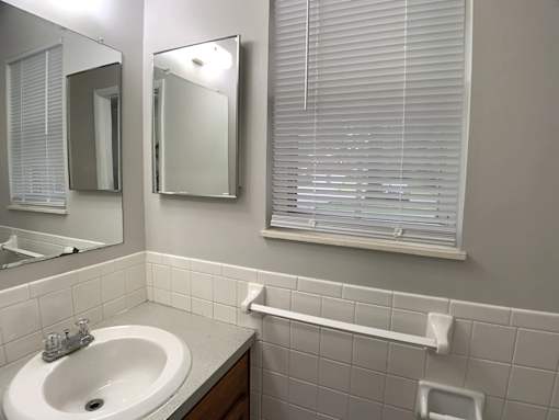 A bathroom with a white sink and a mirror.