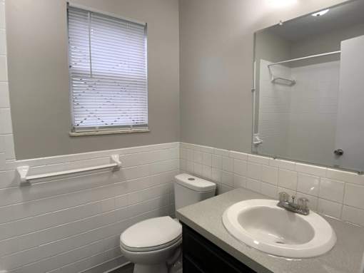 A white toilet sits next to a white sink in a bathroom.