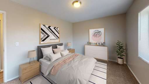 A bedroom with a bed, dresser, nightstand, and lamp.