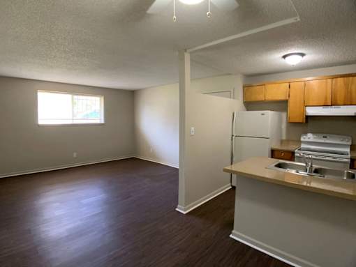 A kitchen area with a refrigerator, sink, and cabinets.