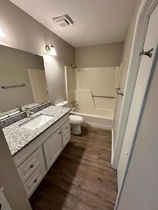 A bathroom with a sink, toilet, and bathtub.