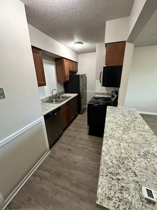 A kitchen with a black fridge and black stove.