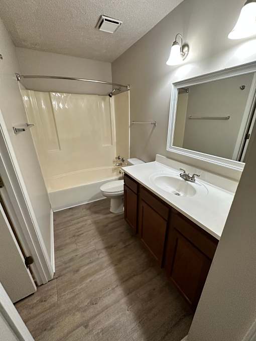 A bathroom with a toilet, sink, and shower.