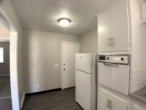 A kitchen with white appliances and cabinets.