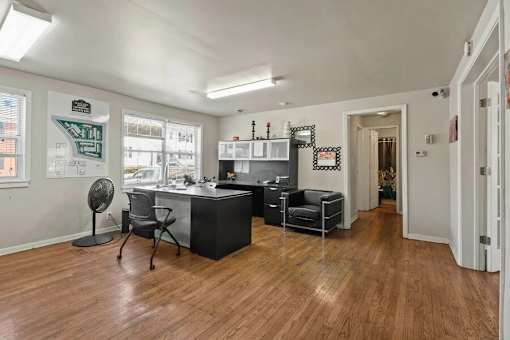A room with a desk and chairs in it.