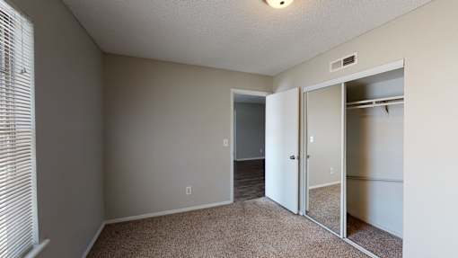 A room with a carpeted floor and a sliding door.