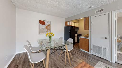 A dining room with a glass table and chairs.