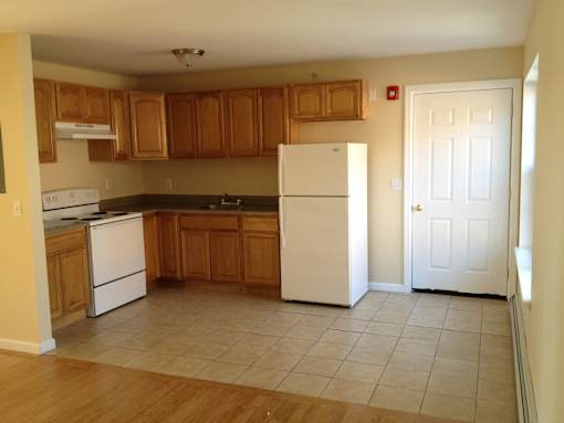 A kitchen with wooden cabinets and white appliances.
