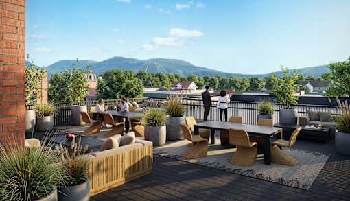A patio with a table and chairs overlooking a mountainous landscape.