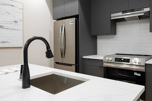 A modern kitchen with a sink and a refrigerator.