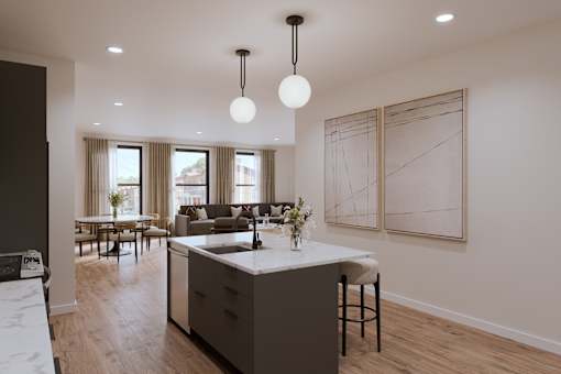 A modern kitchen with a large island and pendant lights.