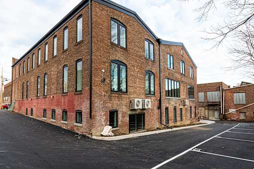 A large brick building with a parking lot in front.