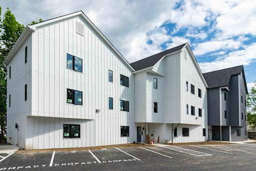 A modern building with white walls and black roofs.