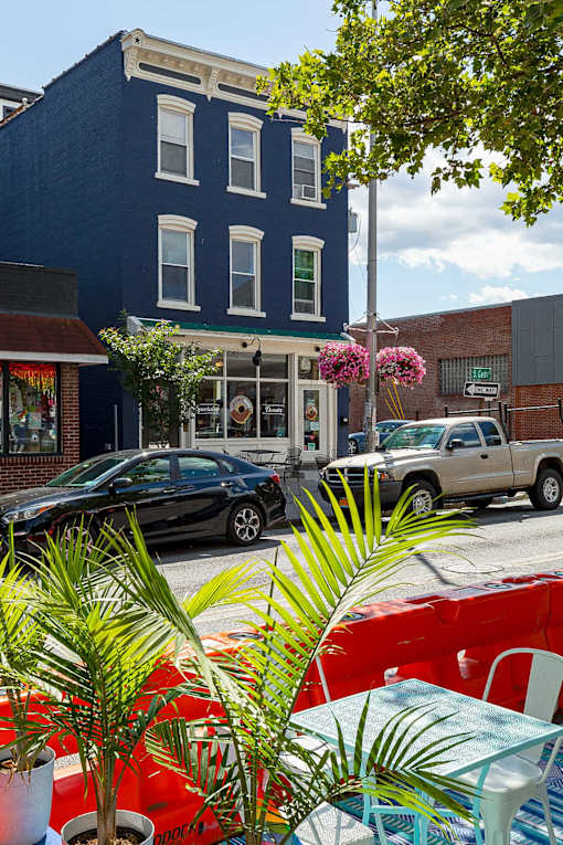 A black car is parked in front of a blue building.