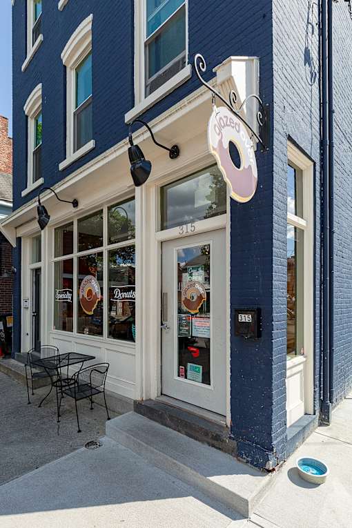 A blue building with a white door and a sign that says "Coffee".