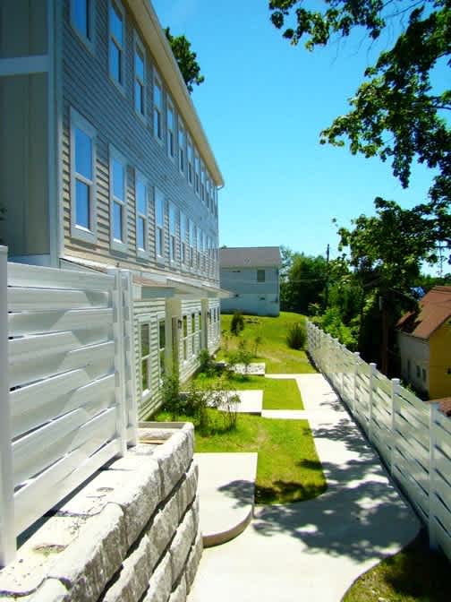 A white building with a white fence in front of it.