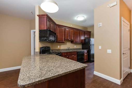 A kitchen with granite countertops and wooden cabinets.