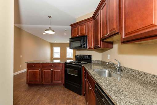A kitchen with brown cabinets and granite countertops.