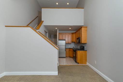 A kitchen with wooden cabinets and a stainless steel refrigerator.