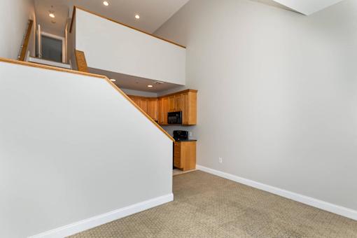 A room with a carpeted floor and a wooden cabinet.