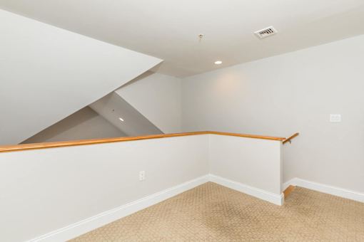 A room with a carpeted floor and a skylight.